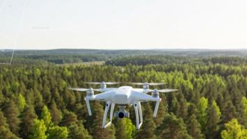 Modern drönare flyger över ett svenskt skogslandskap med en svag kartöverlay