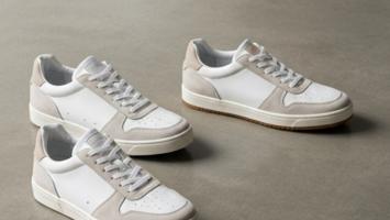 Tre par premium herrsneakers på betonggolv i mjukt studioljus